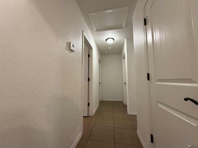 126 N Joe Harper Ct, San Luis, AZ 85349 - hall with tile patterned flooring, baseboards, a textured wall, attic access, and a textured ceiling