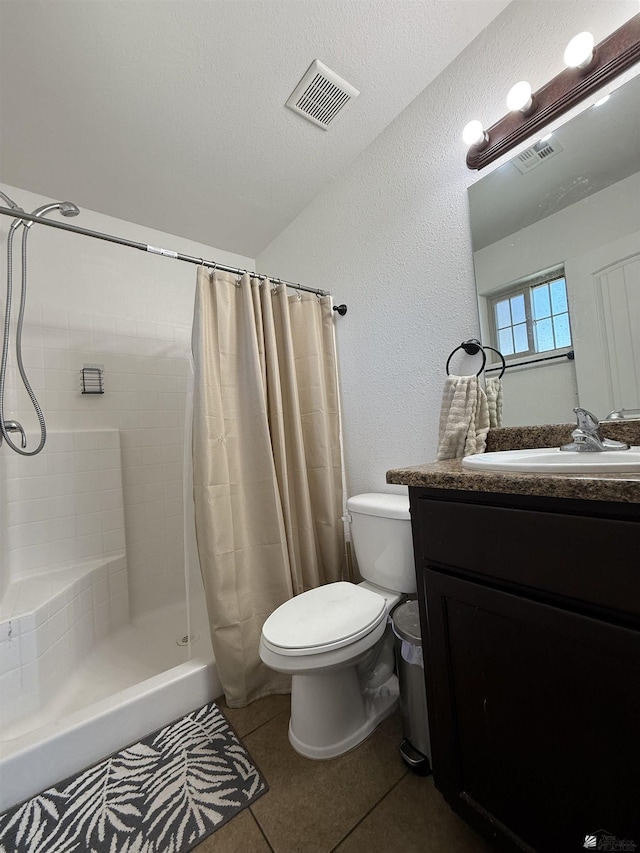126 N Joe Harper Ct, San Luis, AZ 85349 - full bathroom featuring toilet, vanity, tile patterned flooring, a tile shower, and a textured wall