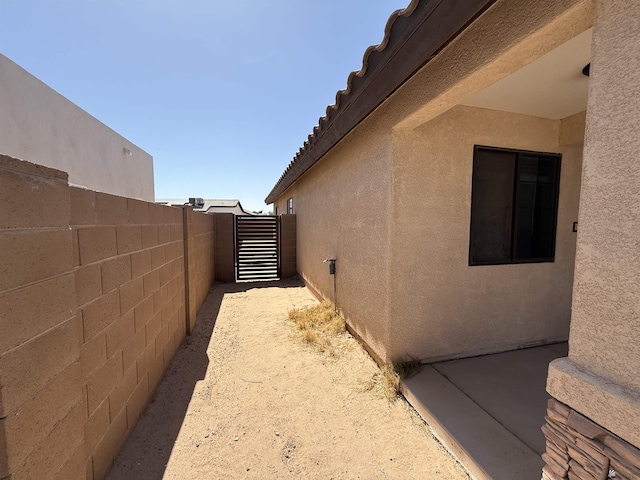 126 N Joe Harper Ct, San Luis, AZ 85349 - view of side of home featuring stucco siding, a gate, and a tiled roof