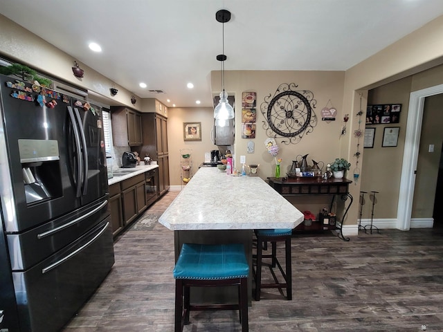 2193 S 40th Dr, Yuma, AZ 85364 - kitchen featuring refrigerator with ice dispenser, light countertops, a peninsula, a breakfast bar area, and dark brown cabinetry