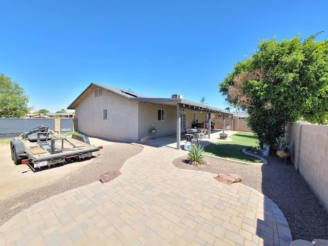 2193 S 40th Dr, Yuma, AZ 85364 - rear view of house featuring a fenced backyard, stucco siding, roof mounted solar panels, and a patio