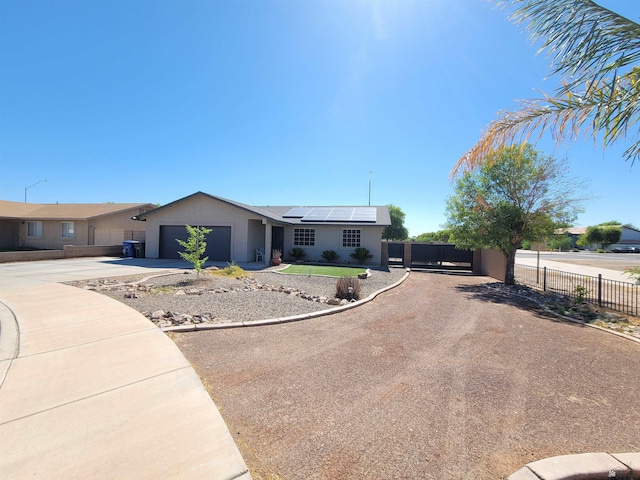 2193 S 40th Dr, Yuma, AZ 85364 - single story home with driveway, roof mounted solar panels, a garage, stucco siding, and a gate