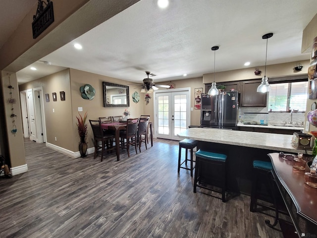 2193 S 40th Dr, Yuma, AZ 85364 - kitchen with stainless steel fridge, a kitchen breakfast bar, dark wood finished floors, recessed lighting, and french doors