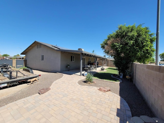 2193 S 40th Dr, Yuma, AZ 85364 - rear view of property featuring stucco siding, a fenced backyard, roof mounted solar panels, and a patio area