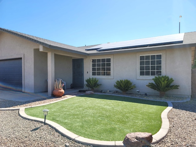 2193 S 40th Dr, Yuma, AZ 85364 - view of front of house with a garage, stucco siding, a front lawn, and roof mounted solar panels