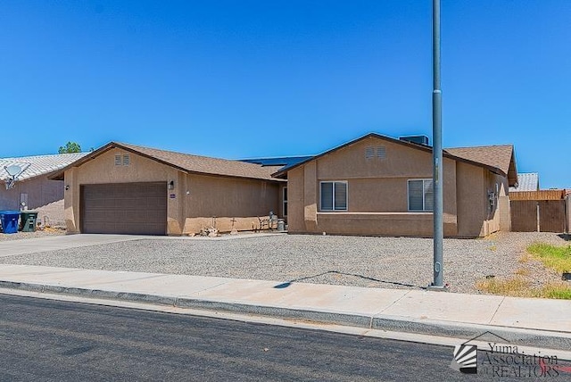 6324 E 45th Ln, Yuma, AZ 85365 - ranch-style home featuring a garage, roof mounted solar panels, stucco siding, and concrete driveway