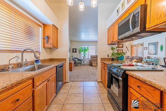6324 E 45th Ln, Yuma, AZ 85365 - kitchen featuring black appliances, light colored carpet, light tile patterned floors, brown cabinetry, and open floor plan