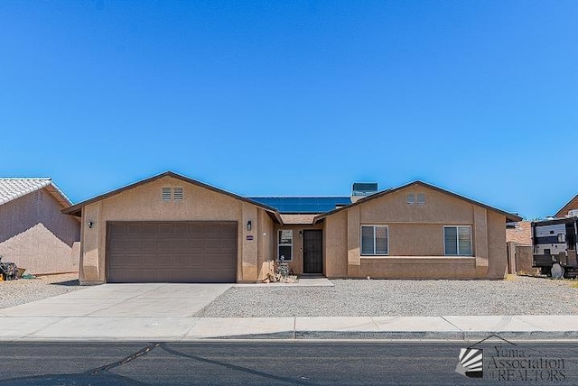 6324 E 45th Ln, Yuma, AZ 85365 - ranch-style house featuring solar panels, a garage, stucco siding, and driveway