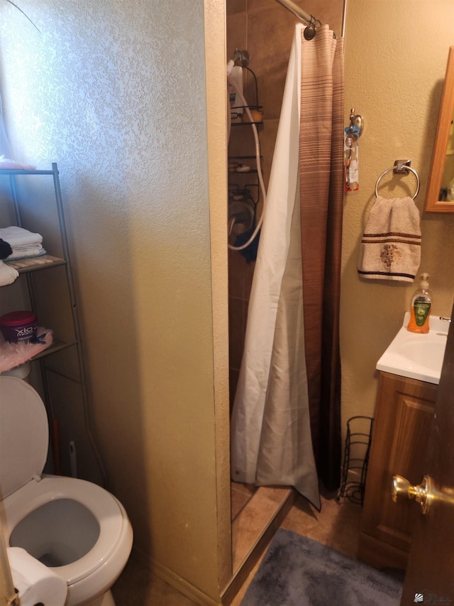 bathroom with toilet, a shower stall, and vanity