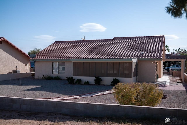 rear view of property featuring stucco siding and a tiled roof