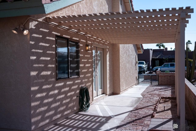 exterior space with a pergola and stucco siding