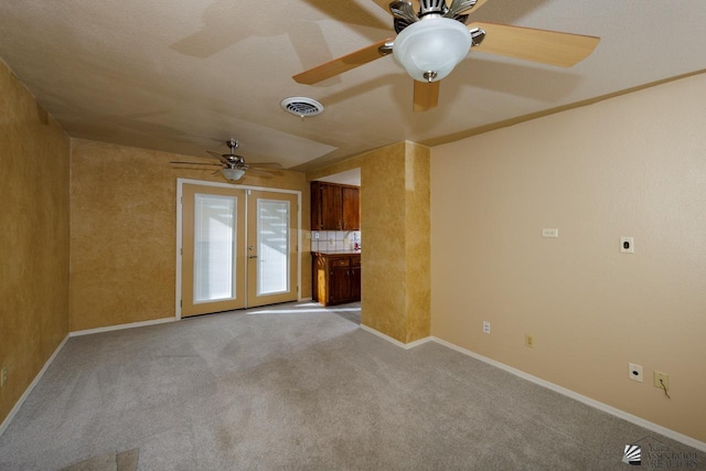 unfurnished living room with french doors, visible vents, light carpet, and baseboards