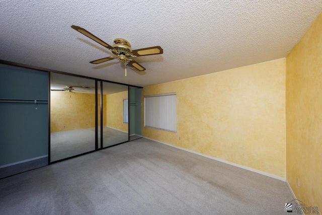 unfurnished bedroom featuring a textured ceiling, a ceiling fan, and carpet flooring