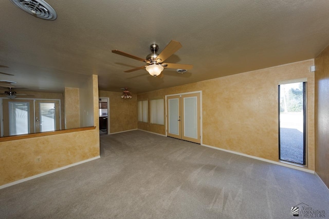 empty room featuring a textured ceiling, ceiling fan, french doors, and visible vents