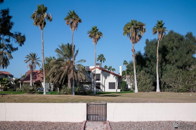 view of front of home with a front yard and a gate