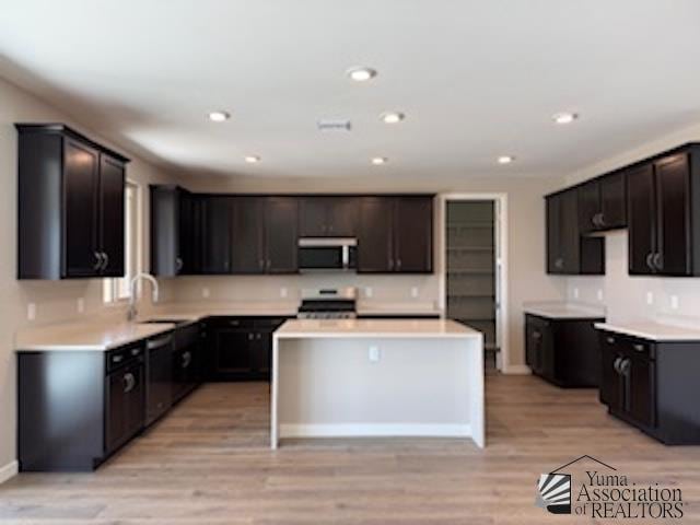 12380 S Grandview Dr, Yuma, AZ 85367 - kitchen featuring stainless steel microwave, dishwasher, stove, light wood-style flooring, and a center island
