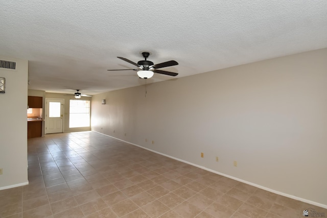 tiled empty room with ceiling fan and a textured ceiling