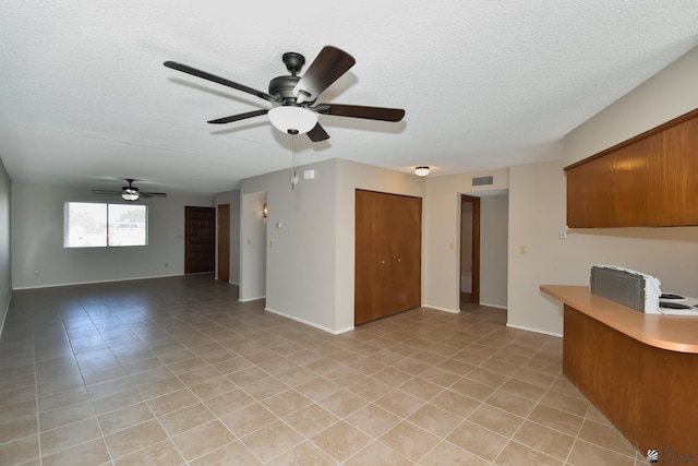 interior space with ceiling fan and a textured ceiling