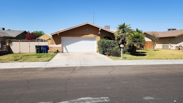 ranch-style home with fence, a garage, driveway, and a front lawn