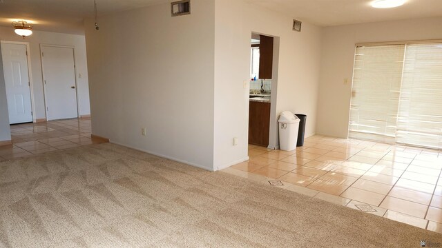 1830 S Athens Ave, Yuma, AZ 85364 - empty room with baseboards, visible vents, light carpet, and light tile patterned floors