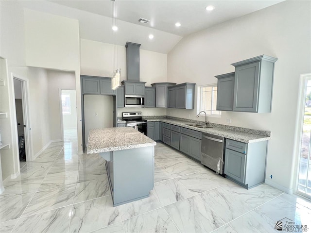 kitchen featuring appliances with stainless steel finishes, gray cabinetry, sink, high vaulted ceiling, and a kitchen island