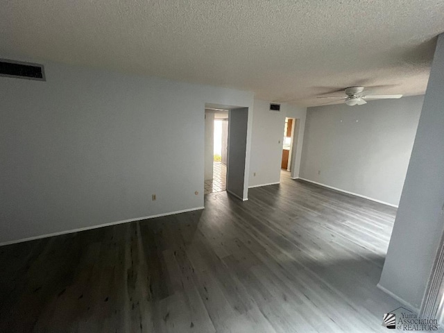 empty room with ceiling fan, dark wood-type flooring, and a textured ceiling