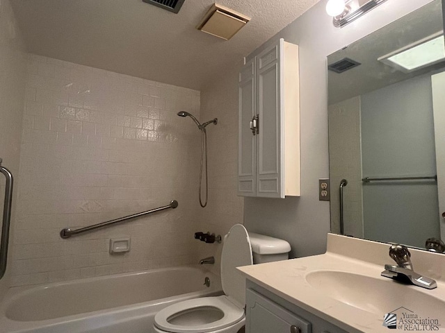 full bathroom featuring tiled shower / bath, vanity, a textured ceiling, and toilet