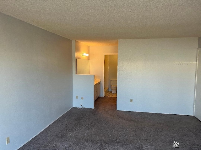 carpeted empty room with a textured ceiling