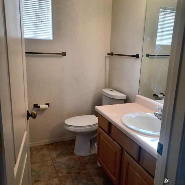 13835 E 51st Ln, Yuma, AZ 85367 - half bathroom featuring toilet, baseboards, plenty of natural light, and vanity