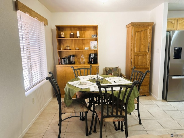 dining space featuring baseboards and light tile patterned floors