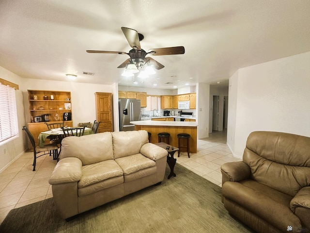 living room with a ceiling fan, baseboards, recessed lighting, light tile patterned floors, and visible vents