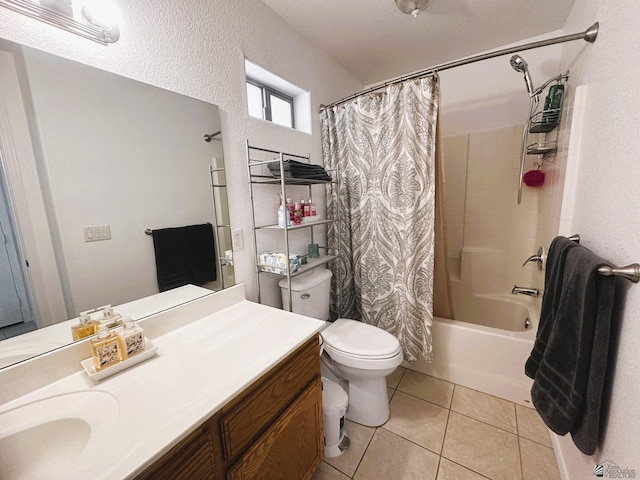 bathroom featuring vanity, shower / tub combo with curtain, a textured wall, toilet, and tile patterned floors