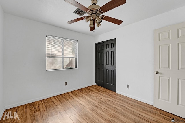 unfurnished bedroom with a closet, baseboards, ceiling fan, and light wood-type flooring