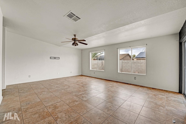 empty room featuring visible vents, a textured ceiling, ceiling fan, and tile patterned floors