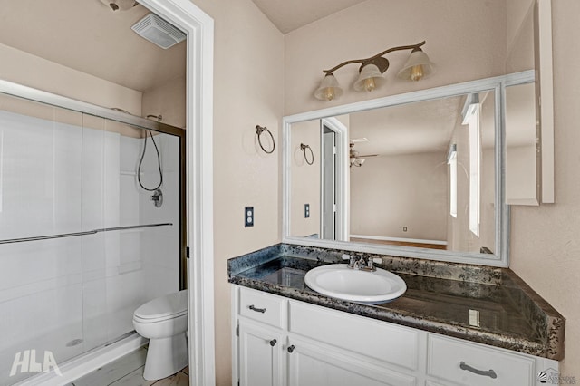 full bath with visible vents, vanity, toilet, and a shower stall
