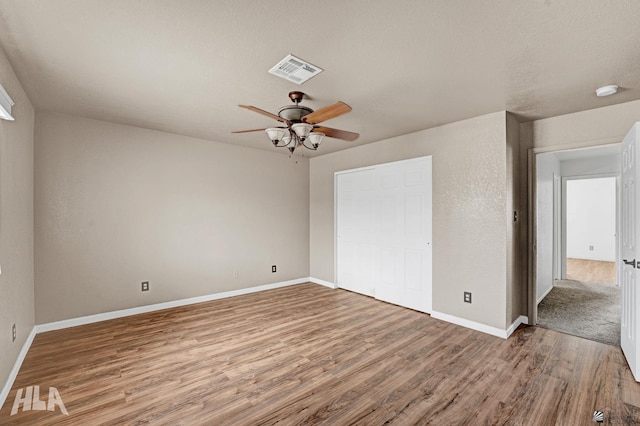 unfurnished bedroom with baseboards, visible vents, and wood finished floors