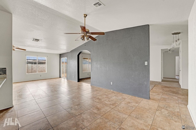 unfurnished room with arched walkways, ceiling fan, visible vents, and light tile patterned floors