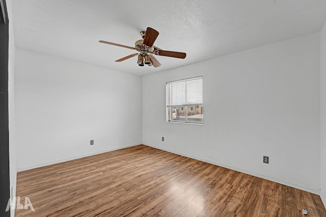 empty room with baseboards, ceiling fan, and wood finished floors