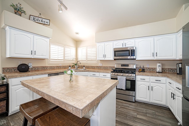 4031 W 16th Pl, Yuma, AZ 85364 - kitchen with appliances with stainless steel finishes, lofted ceiling, a sink, dark wood-style flooring, and white cabinets