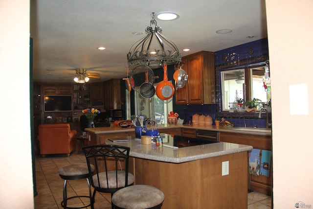 1936 W 15th Pl, Yuma, AZ 85364 - kitchen featuring a sink, light tile patterned floors, black electric stovetop, a breakfast bar area, and dishwasher