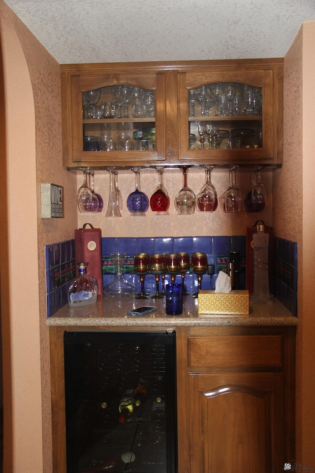 1936 W 15th Pl, Yuma, AZ 85364 - indoor bar featuring wine cooler, a textured ceiling, arched walkways, and a textured wall
