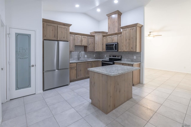 376 N 22nd Dr, San Luis, AZ 85336 - kitchen with backsplash, appliances with stainless steel finishes, a center island, vaulted ceiling, and a sink