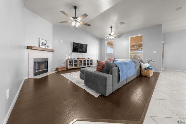 6194 E 46th Ln, Yuma, AZ 85365 - living area featuring vaulted ceiling, a ceiling fan, a tiled fireplace, baseboards, and light wood finished floors