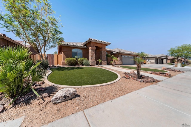 6194 E 46th Ln, Yuma, AZ 85365 - mediterranean / spanish house with concrete driveway, a garage, a tiled roof, stone siding, and stucco siding