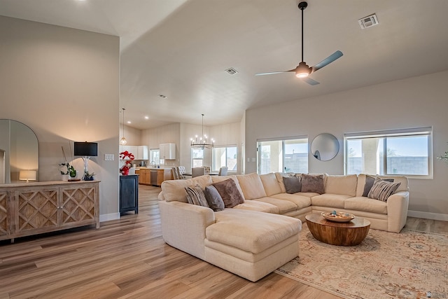 living room with hardwood / wood-style flooring and ceiling fan with notable chandelier