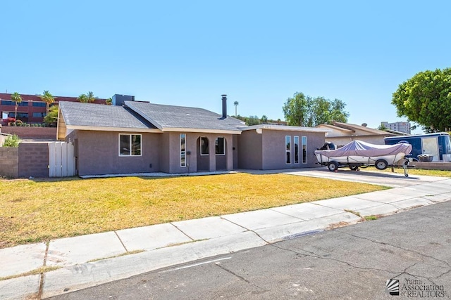 ranch-style house with stucco siding, a front yard, and concrete driveway