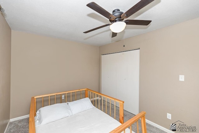 carpeted bedroom with baseboards, ceiling fan, and a closet
