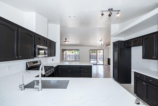 2967 S 47th Ave, Yuma, AZ 85364 - kitchen with appliances with stainless steel finishes, a peninsula, ceiling fan, and light stone countertops