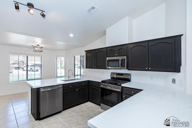 2967 S 47th Ave, Yuma, AZ 85364 - kitchen featuring appliances with stainless steel finishes, a peninsula, backsplash, lofted ceiling, and light tile patterned floors