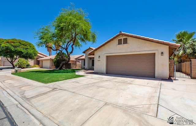2967 S 47th Ave, Yuma, AZ 85364 - view of front of home with stucco siding, an attached garage, driveway, a gate, and a tiled roof